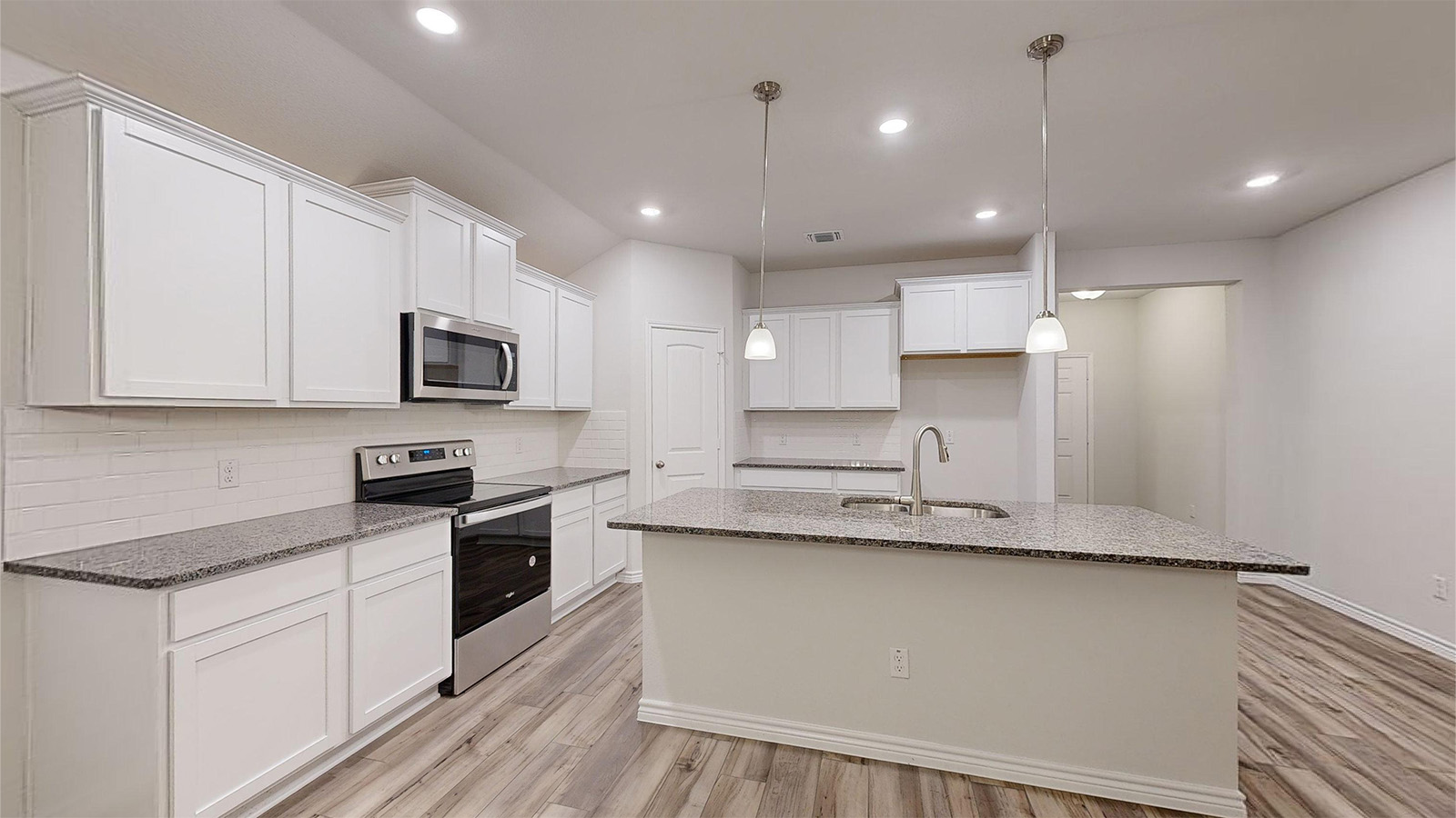 700 Gauge Road Thorndale, TX 76577 - Photo 2 of 22 Kitchen featuring dark stone counters, appliances with stainless steel finishes, backsplash, an island with sink, and recessed lighting