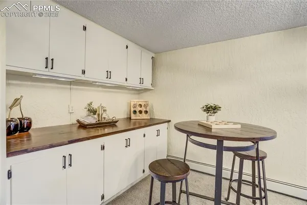 a kitchen with stainless steel appliances granite countertop a sink a stove white cabinets and white countertops with wooden floor