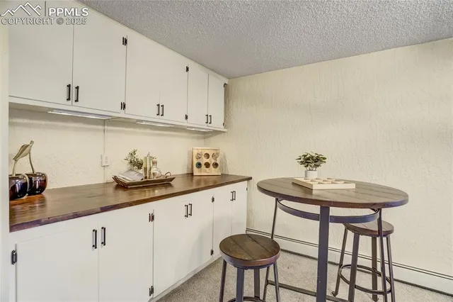 a kitchen with stainless steel appliances granite countertop a sink a stove white cabinets and white countertops with wooden floor