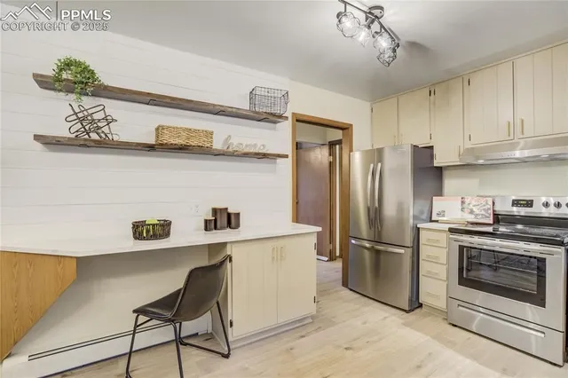 a kitchen with stainless steel appliances granite countertop a refrigerator and a stove top oven