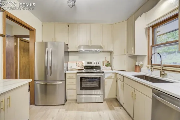 a kitchen with a refrigerator sink and cabinets