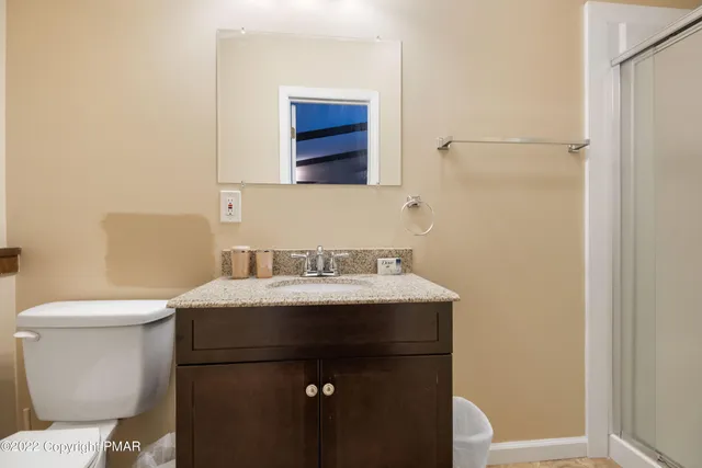 a bathroom with a sink a toilet and mirror