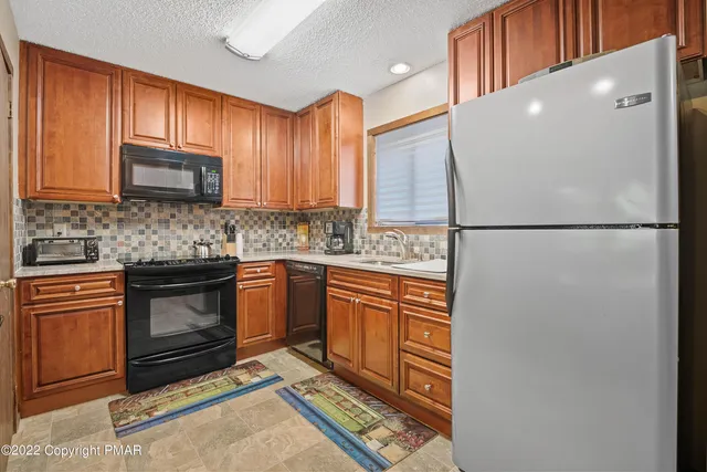 a kitchen with stainless steel appliances granite countertop a refrigerator sink stove microwave and cabinets