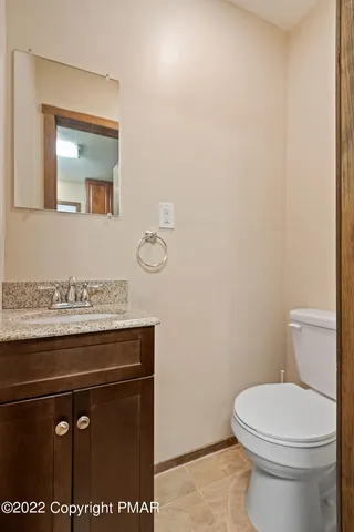 a bathroom with a granite countertop toilet and a sink