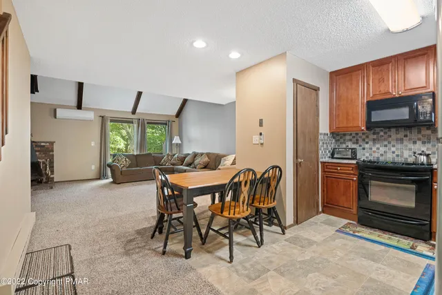 a kitchen with stainless steel appliances kitchen island granite countertop a stove a sink a oven a dining table and chairs