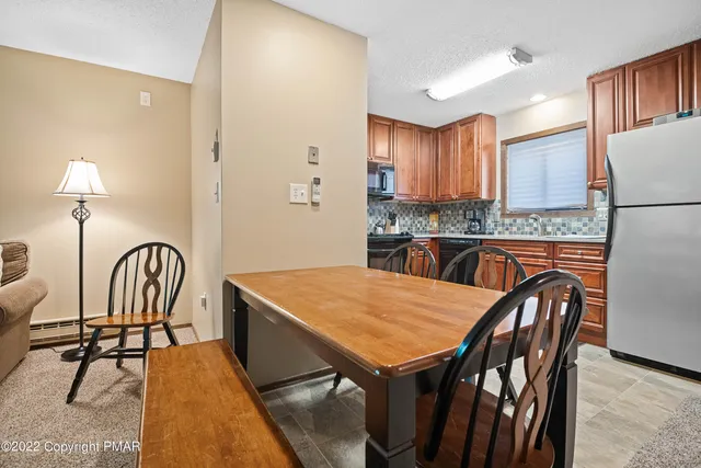 a kitchen with stainless steel appliances kitchen island granite countertop a table chairs in it and wooden floors