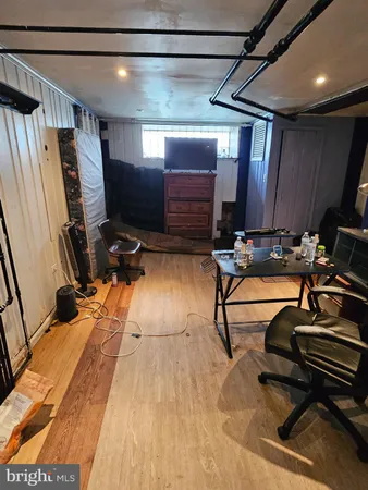 a room with gym equipment and wooden floor