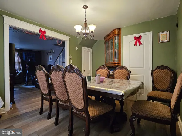 a dining room with furniture a chandelier and wooden floor