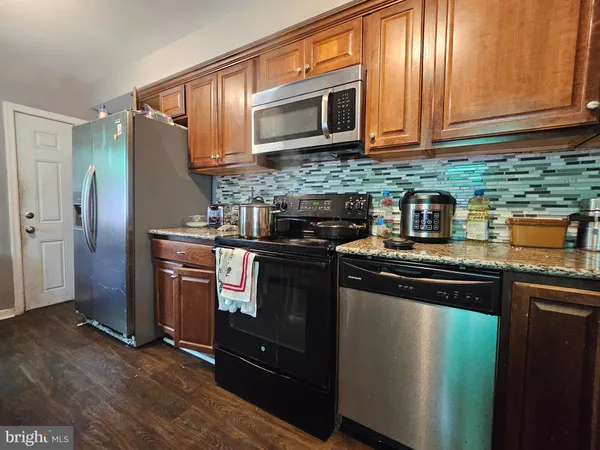 a kitchen with stainless steel appliances granite countertop a refrigerator stove and sink