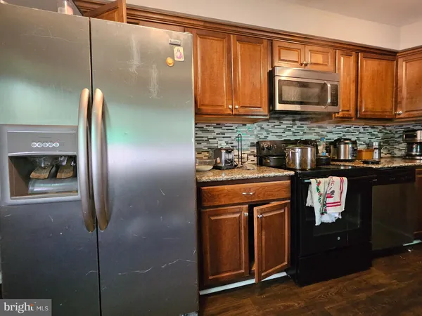 a kitchen with stainless steel appliances granite countertop a refrigerator and a microwave