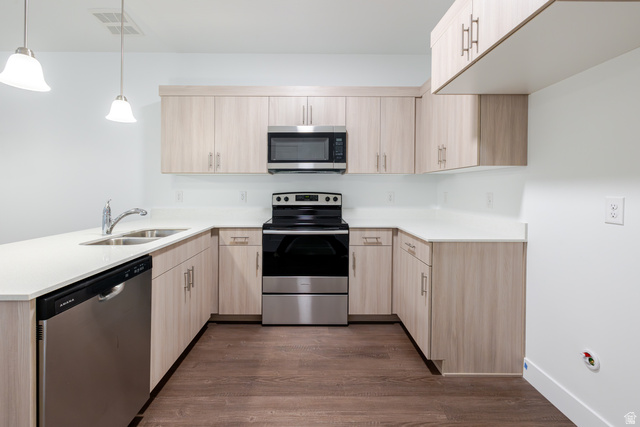 4661 Poplar Way, Unit R302 Mapleton, UT 84664 - Photo 11 of 17 Kitchen with stainless steel appliances, a peninsula, light wood finish cabinetry, dark wood finished floors, and decorative light fixtures