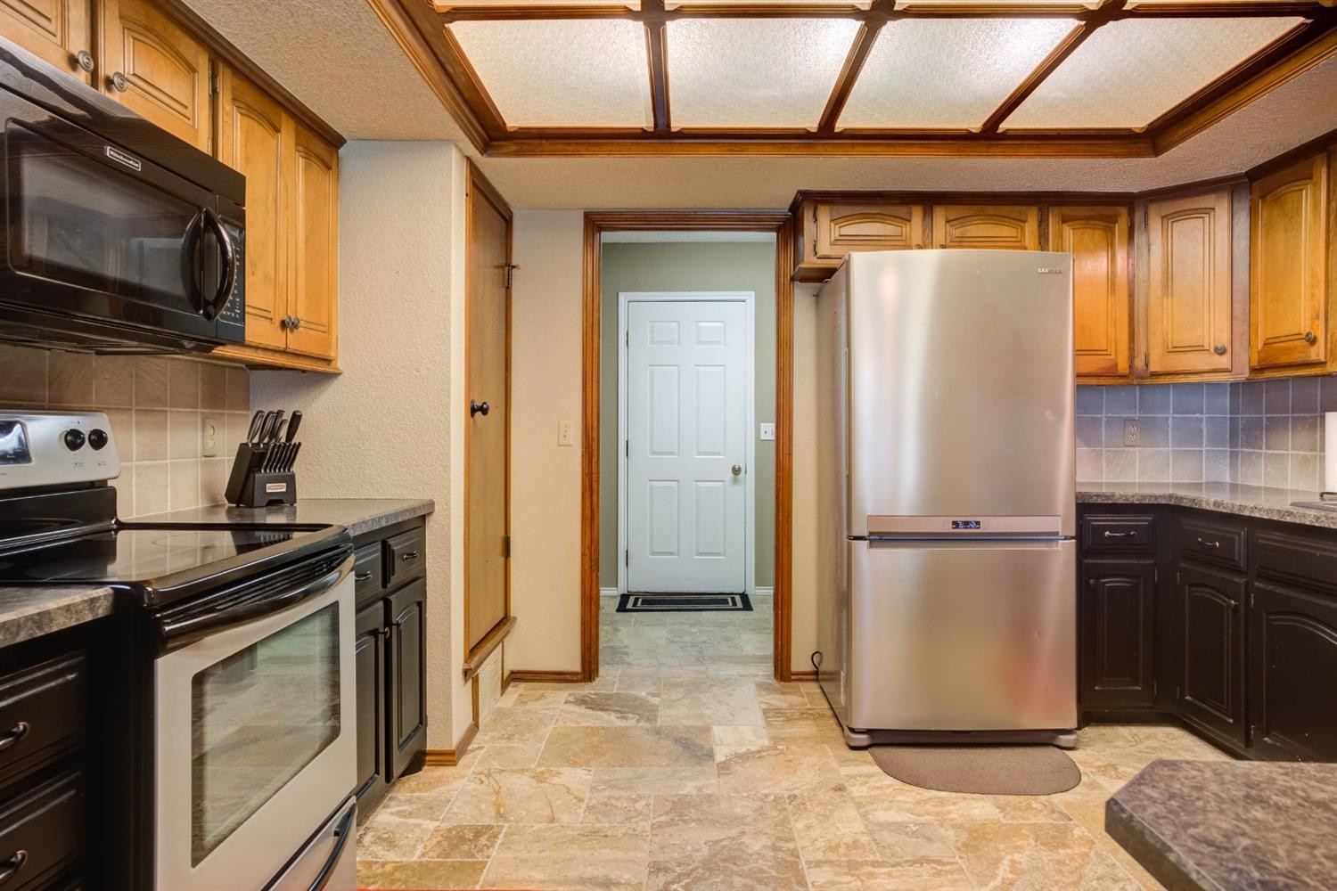 5304 90th Street Lubbock, TX 79424 - Photo 11 of 39 a kitchen with a refrigerator a stove and a microwave