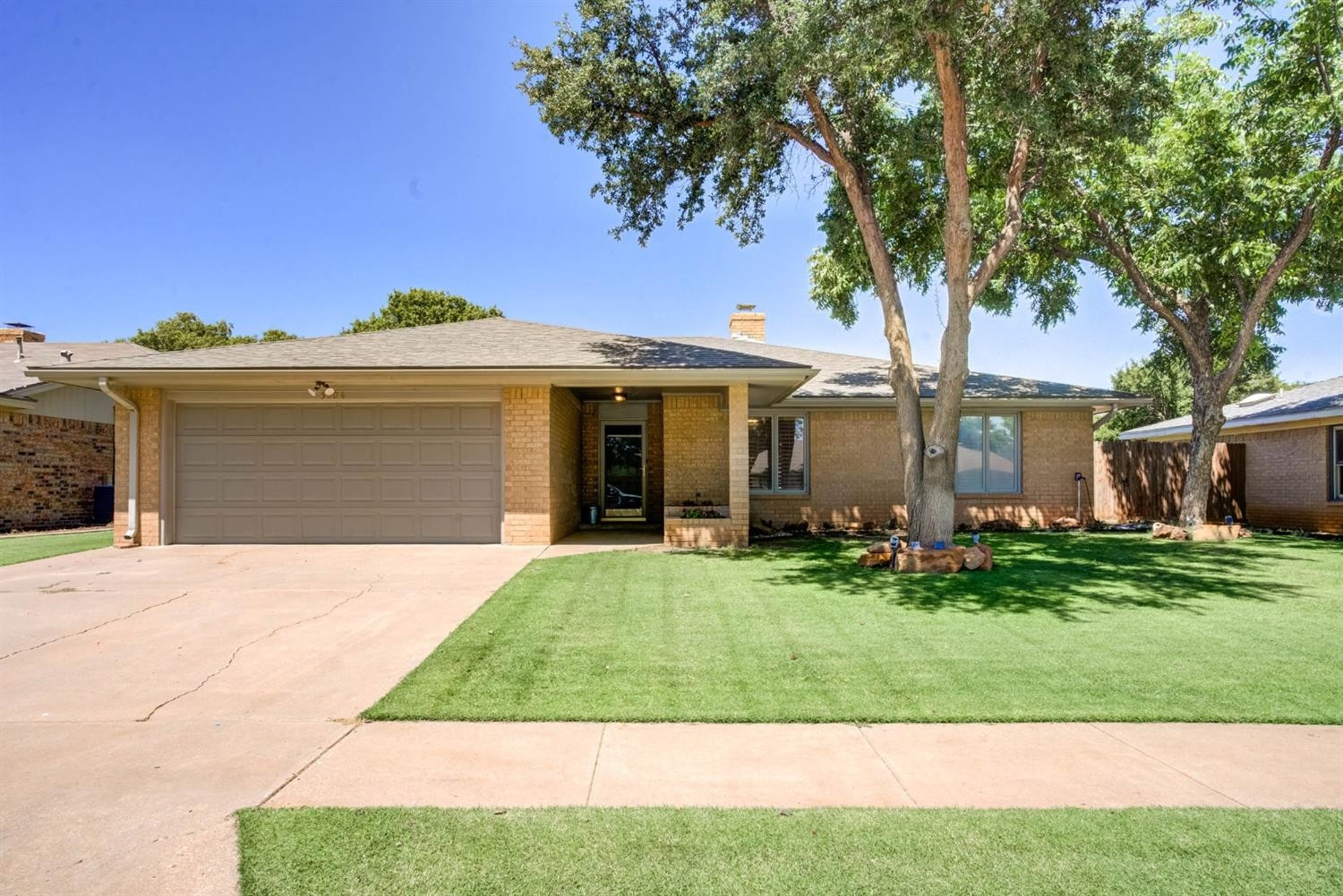 5304 90th Street Lubbock, TX 79424 - Photo 3 of 39 a front view of a house with a garden and trees