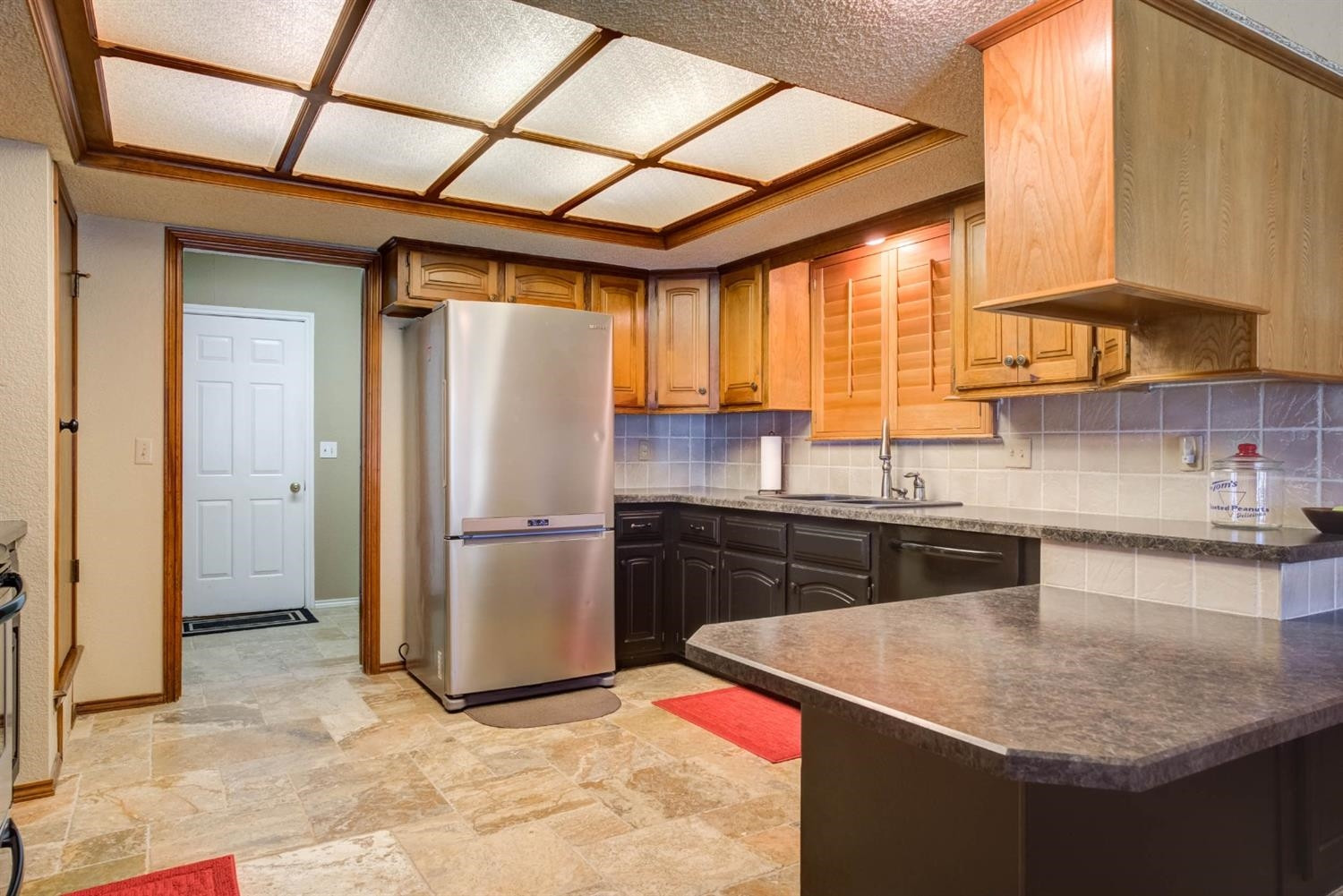 5304 90th Street Lubbock, TX 79424 - Photo 10 of 39 a kitchen with a sink a refrigerator and cabinets