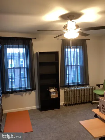 an empty room with windows and ceiling fan