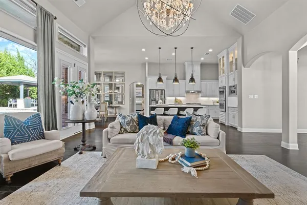 a living room with kitchen island furniture and a chandelier