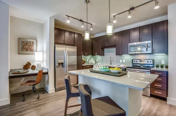 a kitchen with stainless steel appliances granite countertop a sink refrigerator and cabinets