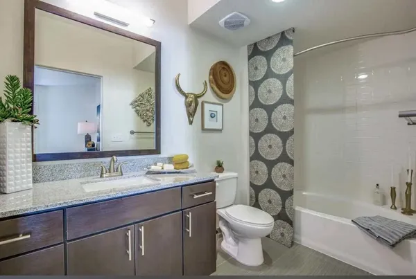 a bathroom with a granite countertop toilet sink and mirror