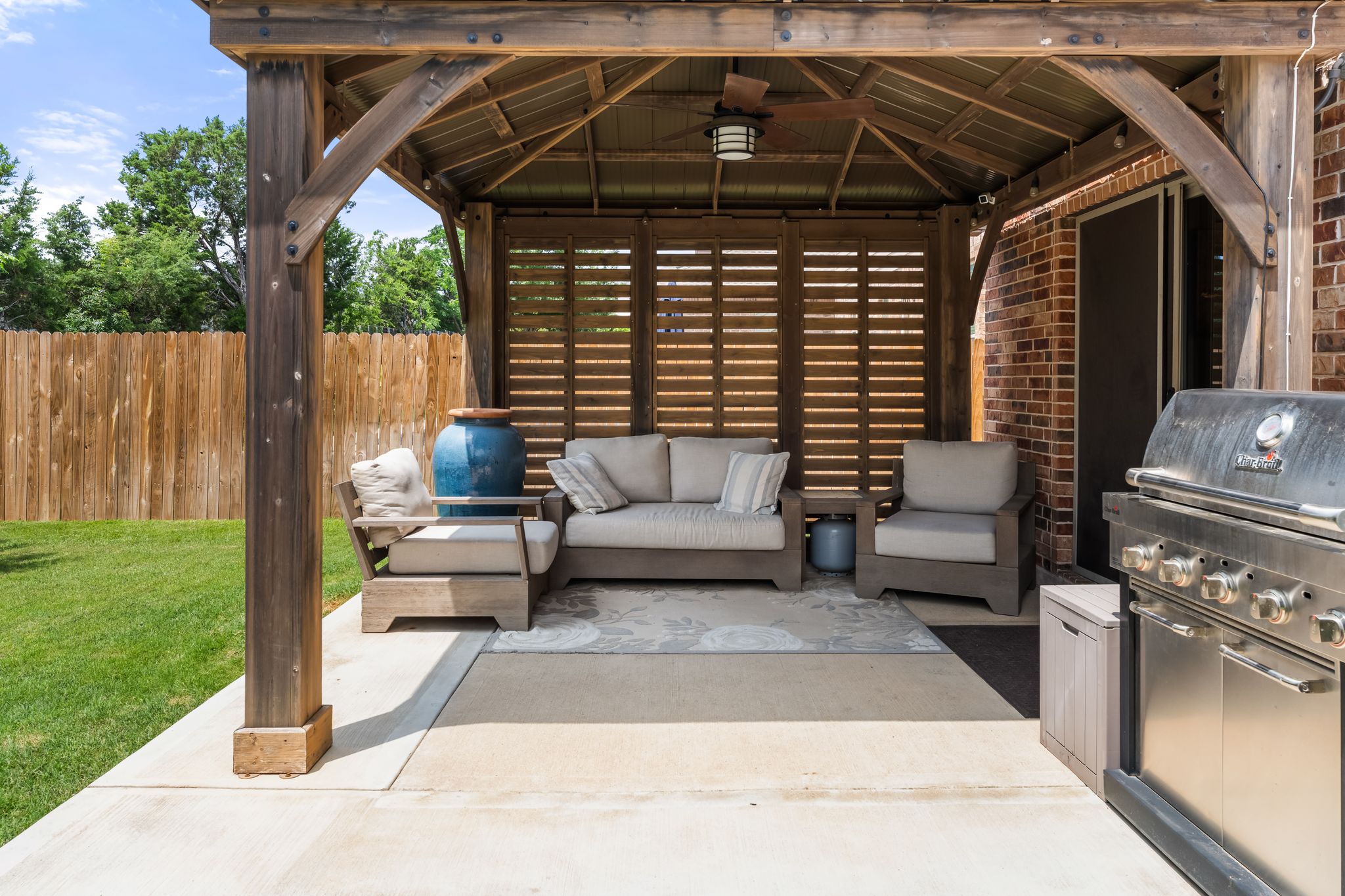 1133 Yellow Iris Road Leander, TX 78641 - Photo 30 of 37 Covered patio featuring a wood-beam pergola with a ceiling fan, slatted wood privacy screen, and a built-in stainless steel grill