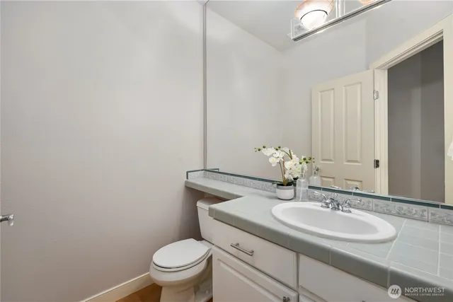a bathroom with a granite countertop sink a toilet and a mirror