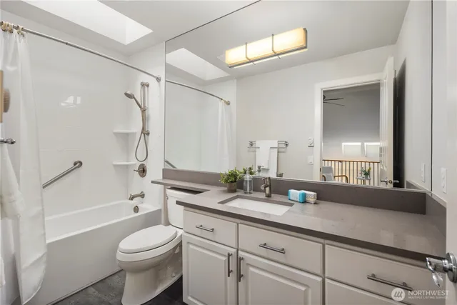 a bathroom with a granite countertop sink a toilet and a bathtub
