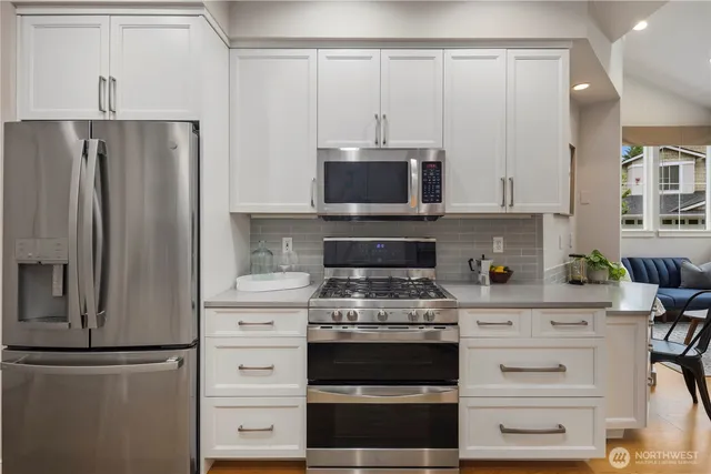 a kitchen with stainless steel appliances white cabinets and a refrigerator