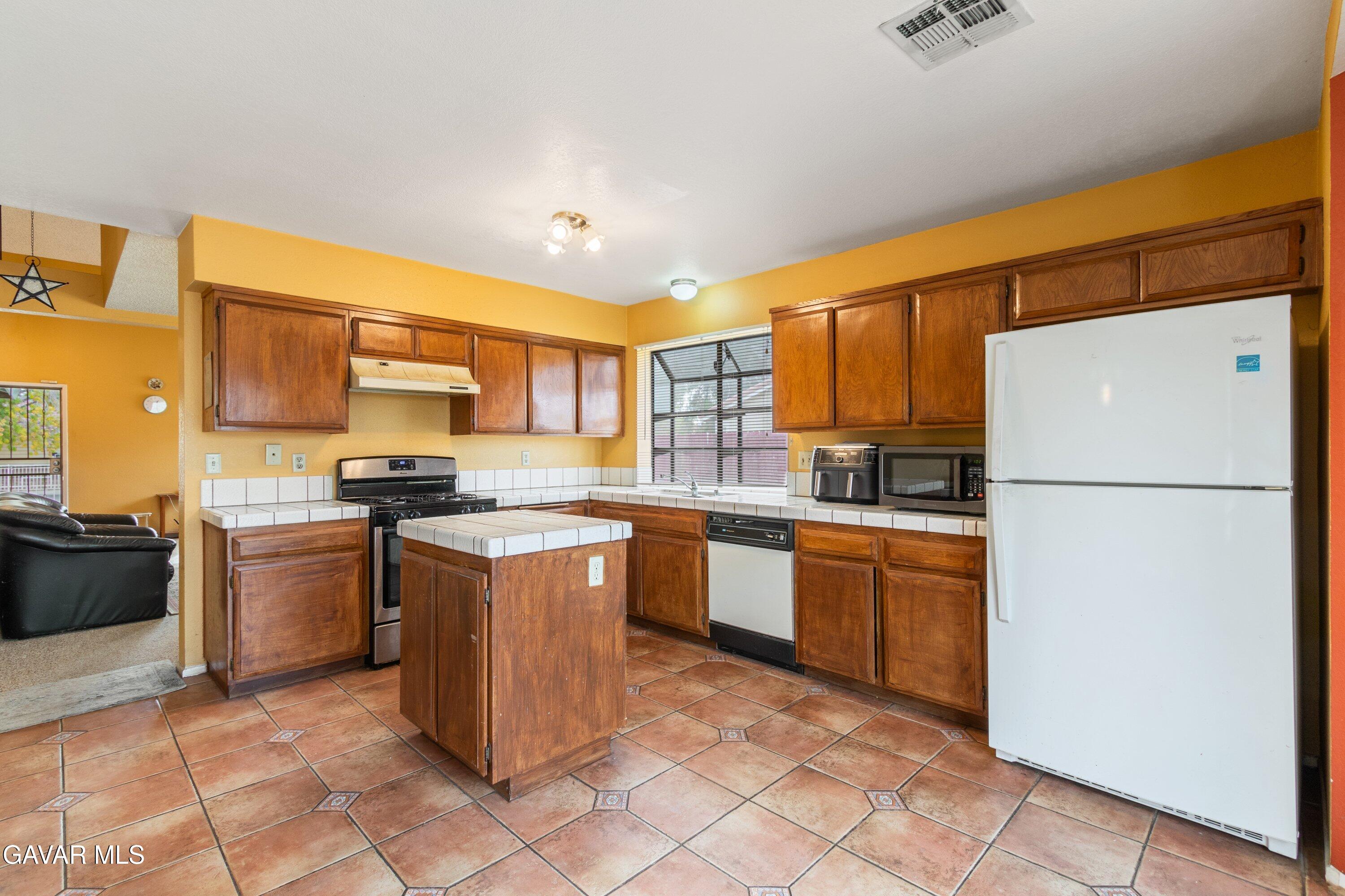 4625 Avenue R6 E Palmdale Ca East Palmdale, CA 93552 - Photo 15 of 25 a kitchen with stainless steel appliances granite countertop a refrigerator stove top oven and sink
