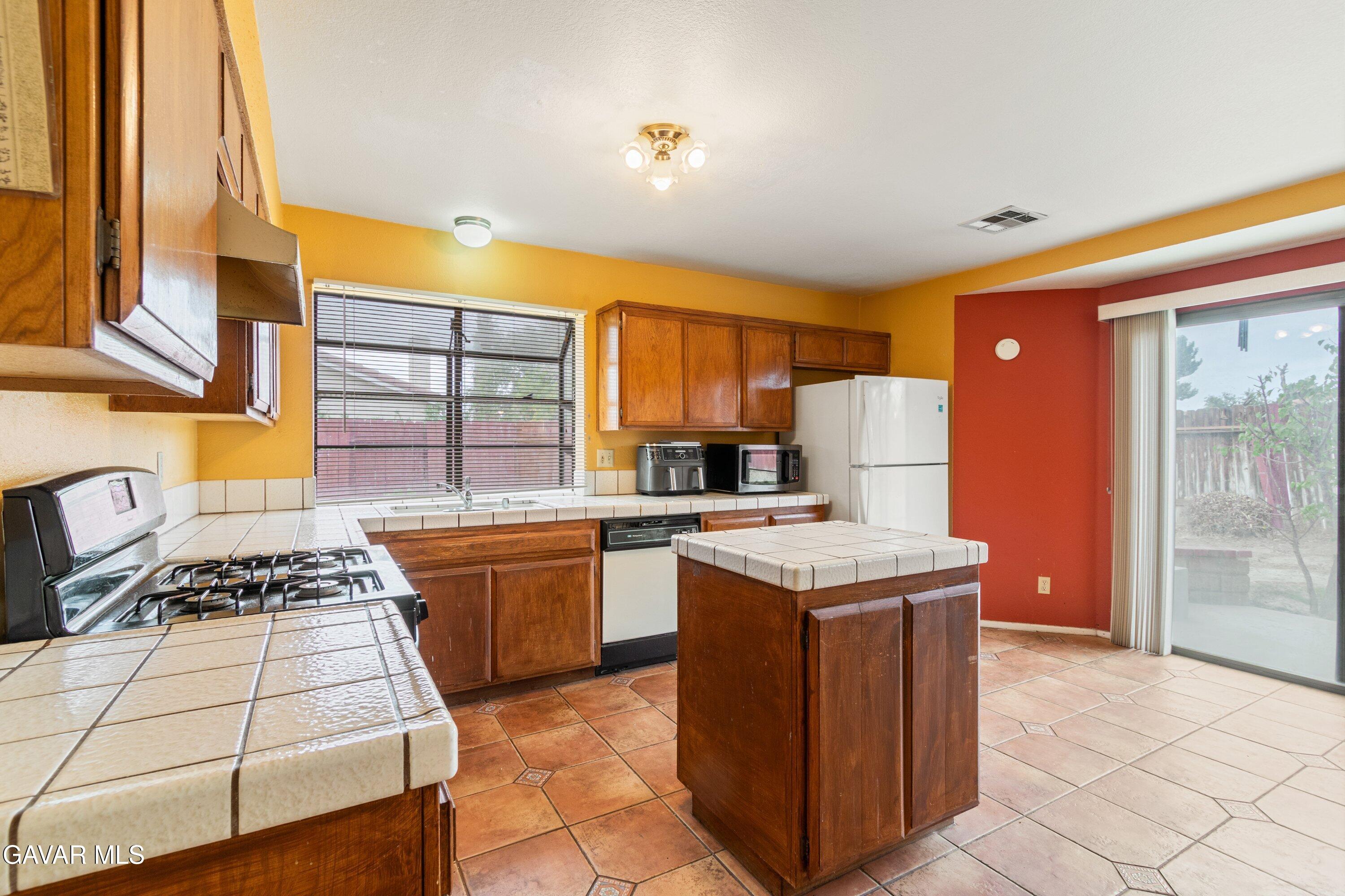 4625 Avenue R6 E Palmdale Ca East Palmdale, CA 93552 - Photo 16 of 25 a kitchen with stainless steel appliances granite countertop a stove a sink and a refrigerator