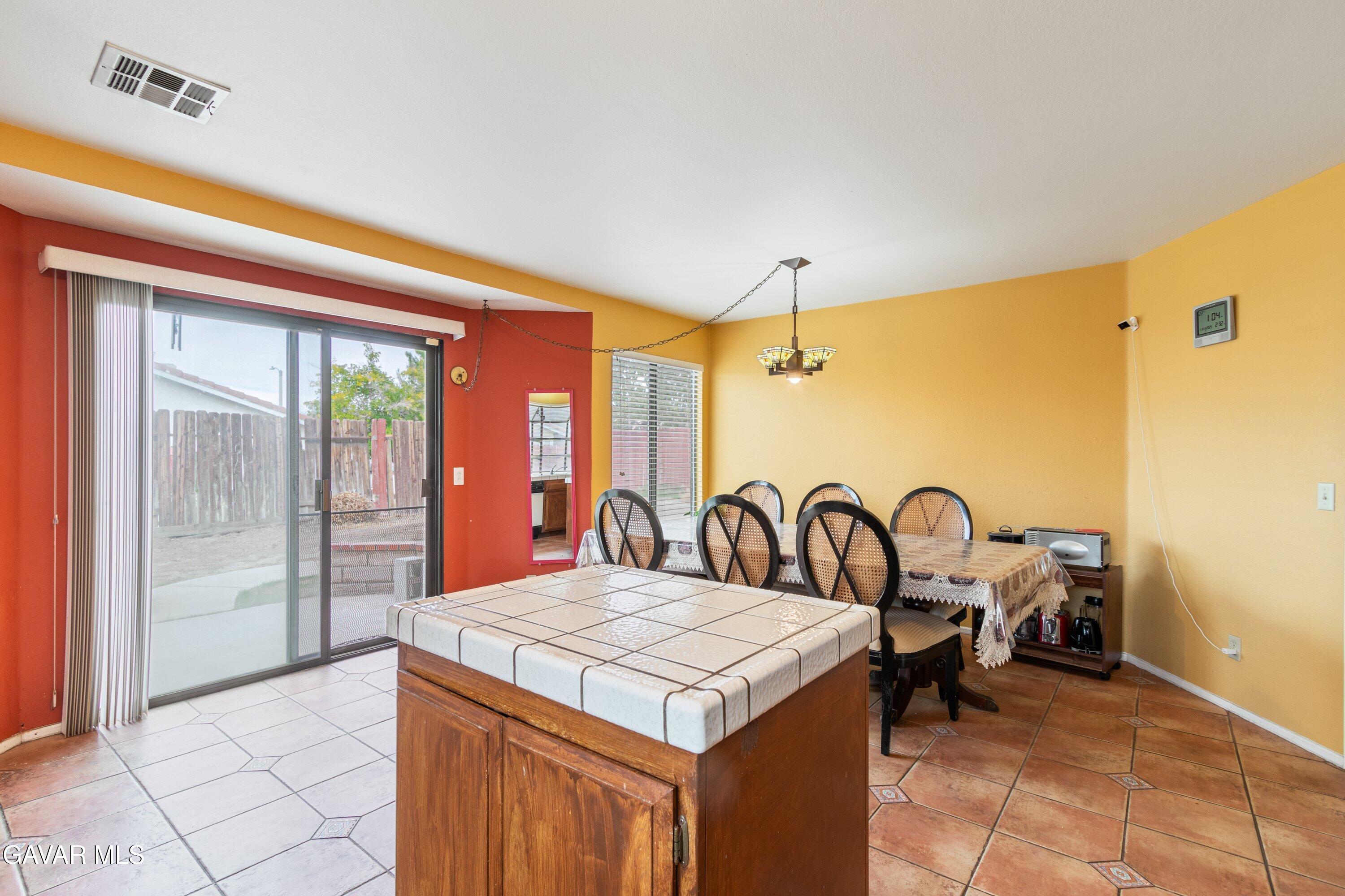 4625 Avenue R6 E Palmdale Ca East Palmdale, CA 93552 - Photo 17 of 25 a kitchen with a refrigerator a table and chairs