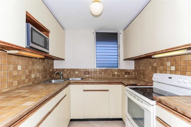 a kitchen with granite countertop a sink and a stove