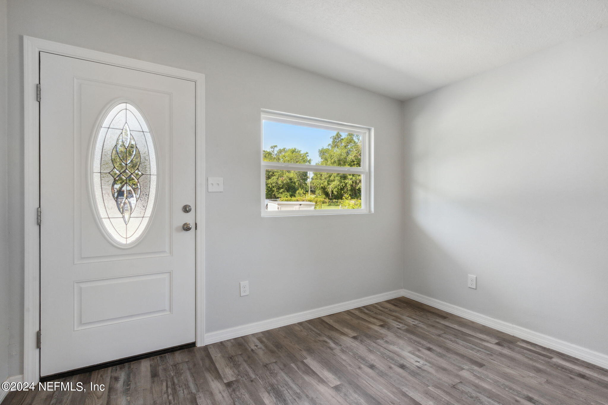 9411 Orme Road Jacksonville, FL 32220 - Photo 6 of 33 an empty room with wooden floor and window