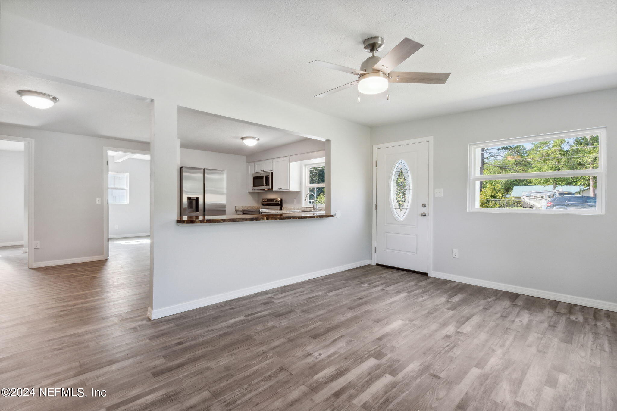 9411 Orme Road Jacksonville, FL 32220 - Photo 9 of 33 a view of an empty room with window and wooden floor