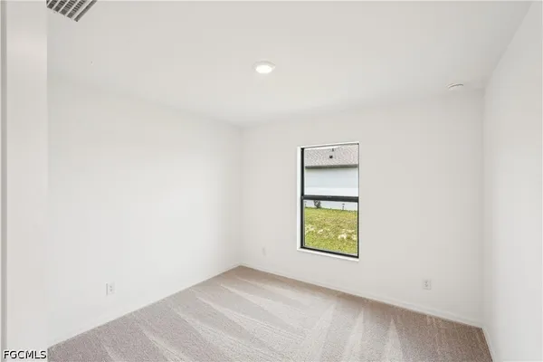 an empty room with a window and mirror