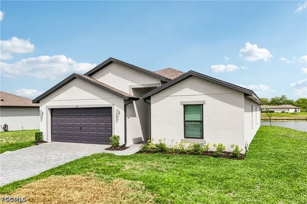 a view of front of house with a yard and garage