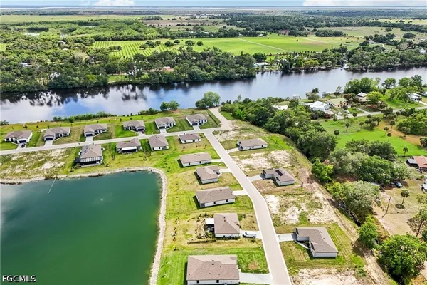 an aerial view of a residential houses with outdoor space and lake view