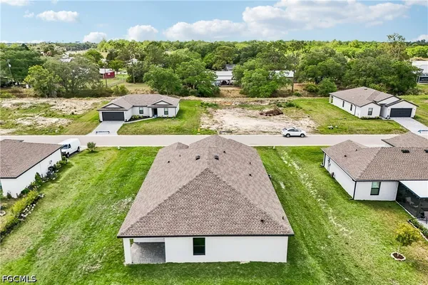 an aerial view of residential houses with outdoor space and lake view