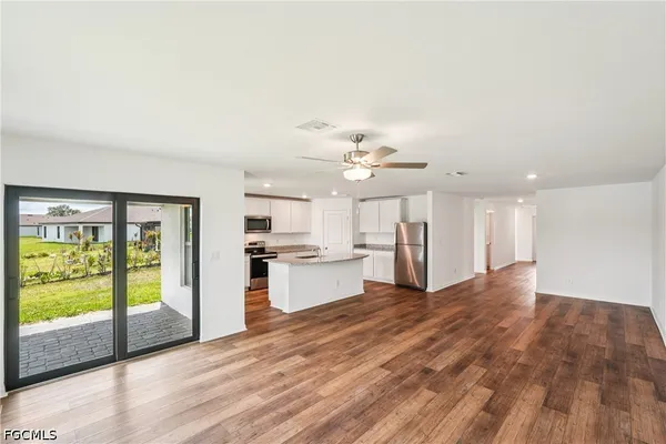a view of a kitchen with wooden floor and electronic appliances