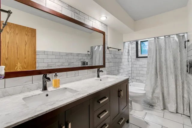 a bedroom with a bed and large windows