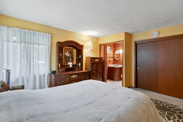 a bed sitting in a bedroom next to a window