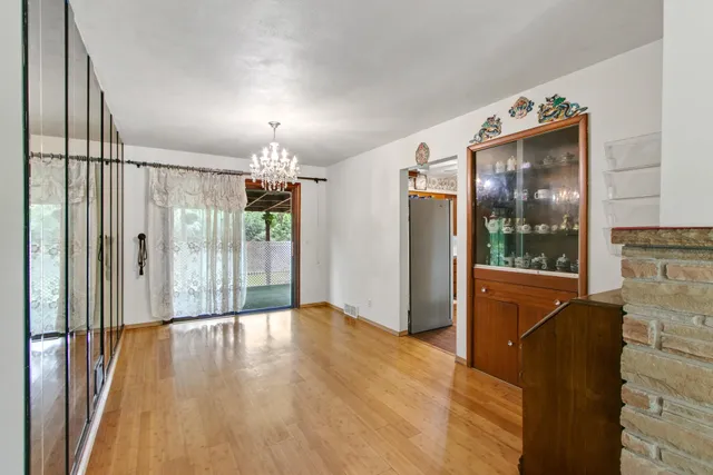 a view of a hallway with wooden floor and a chandelier