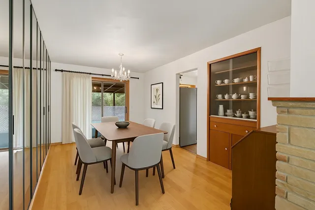 a view of a hallway with wooden floor and a chandelier