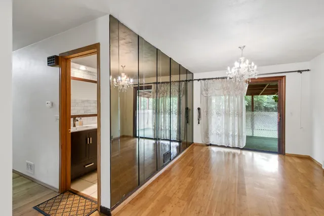 a view of a hallway with wooden floor and a kitchen