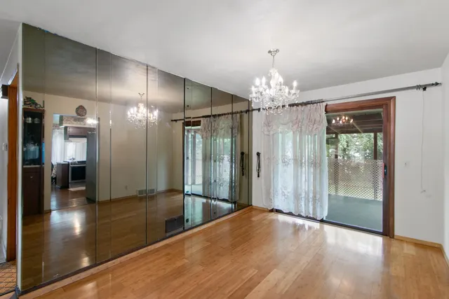 a view of a livingroom with wooden floor and chandelier