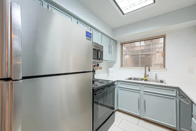 a kitchen with a sink a refrigerator and window