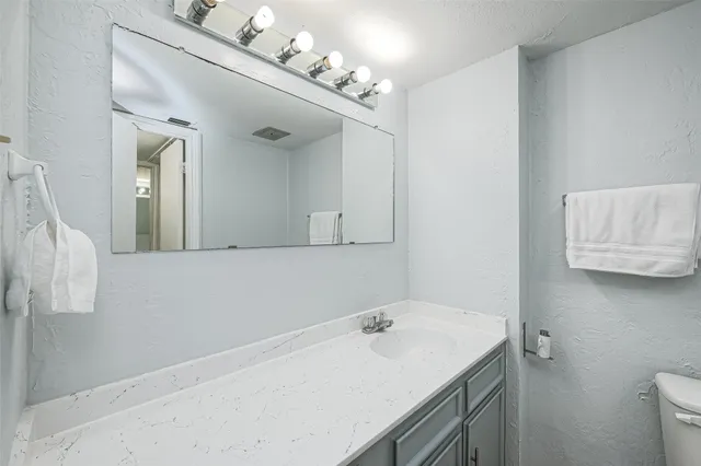 a bathroom with a sink vanity and a mirror