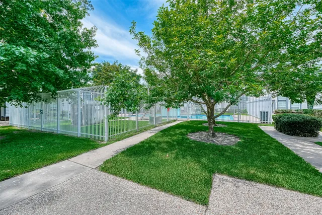 a view of a backyard with iron fence