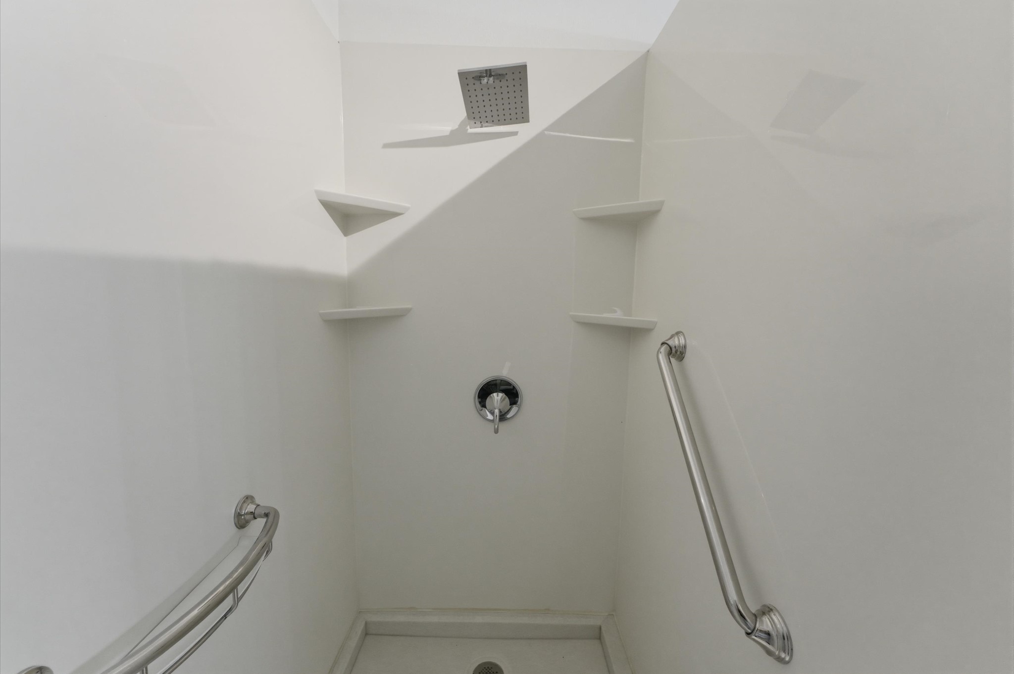 23834 Spring Dane Drive Spring, TX 77373 - Photo 12 of 19 Under a waterfall shower head, notice the built-in shelves for shampoos and shower gels as well as a safety bar for easy entry.