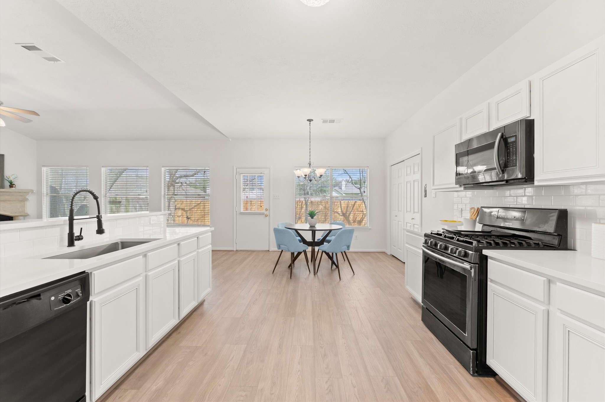 23834 Spring Dane Drive Spring, TX 77373 - Photo 5 of 19 Classic quartz countertops blend seamlessly with ample cabinetry. The gas oven and cooktop rest across from a deep stainless steel sink with a gooseneck faucet.