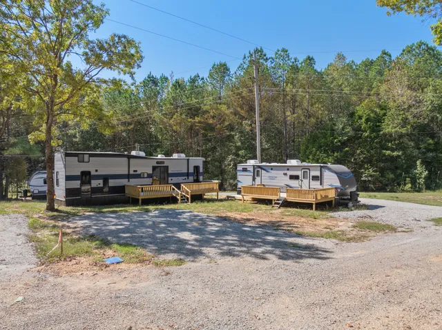 a kitchen with stainless steel appliances granite countertop a refrigerator a oven a sink with wooden floors and chairs