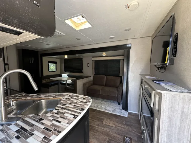 a backyard of a house with barbeque oven and outdoor seating